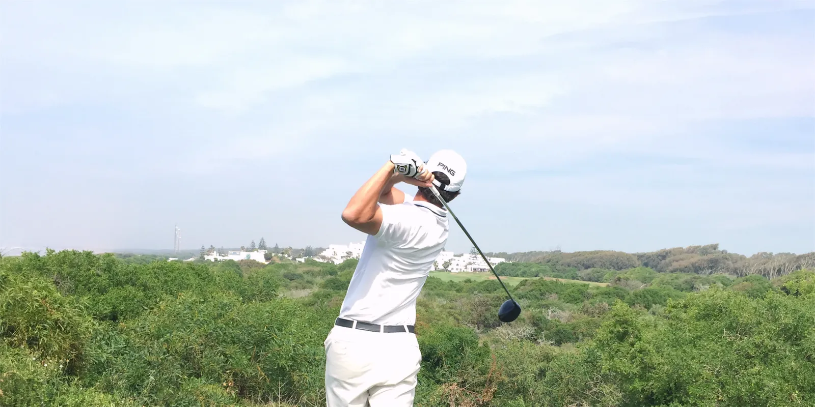 Abschlag mit dem Driver, von hinten über den Golfplatz fotografiert