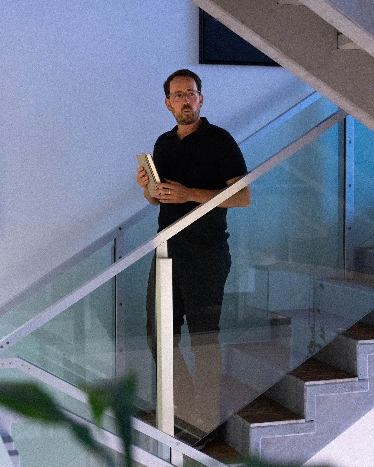Bernhard Neumann mit einem Buch im Treppenhaus