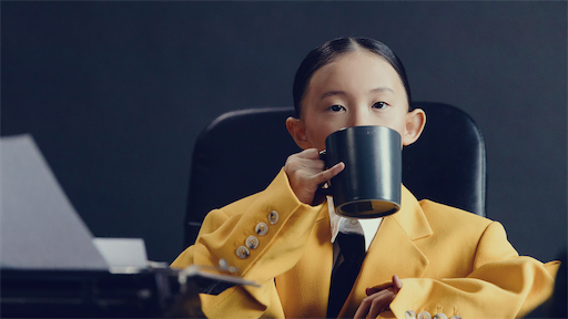 Mädchen im gelben Anzug trinkt Tee